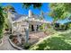 Lush backyard featuring a covered patio, manicured lawn, and beautiful landscaping with mature trees at 7109 Deepriver Cir, Las Vegas, NV 89129