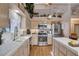 Well-equipped kitchen with stainless steel appliances, tile countertops, and a view of the upper level at 7109 Deepriver Cir, Las Vegas, NV 89129