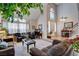 Bright living room with large windows, vaulted ceilings, and a view of the staircase at 7109 Deepriver Cir, Las Vegas, NV 89129