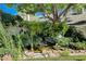 Backyard pond surrounded by lush greenery and rock features create a tranquil outdoor oasis in this home at 7109 Deepriver Cir, Las Vegas, NV 89129