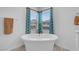 Close-up shot of a white bathtub, with blue patterned curtains in the background at 7260 Grace Estate Ave, Las Vegas, NV 89113