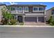 Beautiful home featuring a three-car garage, stone accents, neutral paint, and manicured landscaping at 7260 Grace Estate Ave, Las Vegas, NV 89113