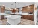 Spacious kitchen with stainless steel appliances, large island, wood cabinets and modern pendant lighting at 7260 Grace Estate Ave, Las Vegas, NV 89113