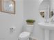 Clean powder room with toilet, sink, round mirror, wood-look floors and neutral paint at 7260 Grace Estate Ave, Las Vegas, NV 89113