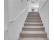 Carpeted staircase with white railing and bright, neutral walls at 7260 Grace Estate Ave, Las Vegas, NV 89113