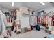 A well-organized walk-in closet with a variety of clothing, shoes, and storage boxes at 7260 Grace Estate Ave, Las Vegas, NV 89113