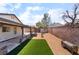 Backyard featuring desert landscaping, a covered patio, artificial turf and a tall brick fence at 806 Fireweed Dr, Henderson, NV 89002