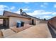 Spacious backyard featuring concrete, brick patio, garbage bins, and partial home view under a blue sky at 806 Fireweed Dr, Henderson, NV 89002