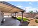 The backyard has a covered patio, desert landscaping, a stone statue and a tall brick fence at 806 Fireweed Dr, Henderson, NV 89002