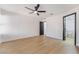 Large bedroom with hardwood floors, ceiling fan, and an ensuite bathroom featuring a toilet and walk-in shower at 806 Fireweed Dr, Henderson, NV 89002