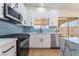 Modern kitchen with stainless steel appliances, blue backsplash, white cabinets, and marble countertops at 806 Fireweed Dr, Henderson, NV 89002