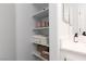 Bathroom storage with white shelving, towels, and baskets near vanity at 820 Bernini St, Las Vegas, NV 89144