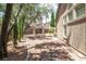 A spacious backyard featuring gravel, a covered patio, mature landscaping and an outdoor kitchen with a built-in grill at 8800 Cortile Dr, Las Vegas, NV 89134