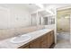 Bathroom featuring dual sinks, large mirror, and tiled shower/tub enclosure at 8800 Cortile Dr, Las Vegas, NV 89134