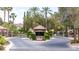 The gated community entrance features lush landscaping and a guard house, offering security and a welcoming entry at 8800 Cortile Dr, Las Vegas, NV 89134
