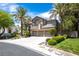 Charming two-story home featuring desert landscaping with palm trees and a three-car garage at 8800 Cortile Dr, Las Vegas, NV 89134