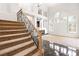 Spacious living room with high ceilings, large windows, and carpeted staircase at 8800 Cortile Dr, Las Vegas, NV 89134