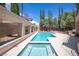 A stunning pool and jacuzzi area with a covered patio featuring clear blue water and ample space for relaxation and entertainment at 8800 Cortile Dr, Las Vegas, NV 89134