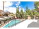 A patio overlooks a refreshing pool surrounded by lush greenery and trees, offering a relaxing outdoor space at 8800 Cortile Dr, Las Vegas, NV 89134