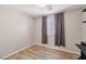 Bedroom features wood-look floors, ceiling fan and a window with blinds and dark curtains at 9053 Entrancing Ave, Las Vegas, NV 89149