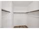 Walk-in closet with wood-look floors, white walls, and metal rods for hanging clothes at 9053 Entrancing Ave, Las Vegas, NV 89149