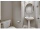Powder room features a modern pedestal sink, toilet, and round mirror at 9140 Entrancing Ave, Las Vegas, NV 89149