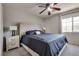 Cozy bedroom featuring a tufted headboard, ceiling fan, and a window bringing in plenty of natural light at 9140 Entrancing Ave, Las Vegas, NV 89149