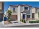 Two-story home with a beige stucco exterior, a blue front door, and an attached one-car garage at 9140 Entrancing Ave, Las Vegas, NV 89149