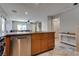 Bright kitchen features wooden cabinets, stainless steel appliances, and flows into the living room at 9140 Entrancing Ave, Las Vegas, NV 89149