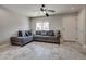 Living room featuring gray tile flooring, a comfortable sectional sofa, and a ceiling fan at 9140 Entrancing Ave, Las Vegas, NV 89149