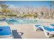Community pool featuring clear water, lounge chairs, and mature trees, providing a relaxing atmosphere at 9140 Entrancing Ave, Las Vegas, NV 89149