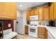 Kitchen with white appliances and natural wood cabinetry, creating a warm atmosphere at 939 Paisley St, Las Vegas, NV 89145