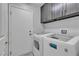 Functional laundry room with washer, dryer, storage cabinets, and a convenient utility sink at 9585 Teton Diablo Ave, Las Vegas, NV 89117