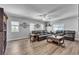 Spacious living room featuring hardwood floors, large windows, and leather sofas at 9585 Teton Diablo Ave, Las Vegas, NV 89117