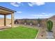 Backyard with desert landscaping, artificial grass, and covered patio at 9886 Alpine Style Dr, Las Vegas, NV 89166