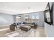 Spacious living room with plush sectional sofa, neutral tile flooring, and lots of natural light at 9886 Alpine Style Dr, Las Vegas, NV 89166