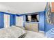 Main bedroom featuring blue walls, carpet, dresser, and wall mounted TV at 9886 Alpine Style Dr, Las Vegas, NV 89166