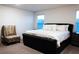 Serene bedroom showcasing a tufted bed, chair and large window views at 10021 Locking Biner Ave, Las Vegas, NV 89166