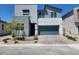 Modern two-story home featuring a gray stucco exterior, brick driveway, and a two-car garage at 10021 Locking Biner Ave, Las Vegas, NV 89166