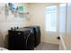 Efficient laundry room with modern, dark appliances, shelving, and natural light at 10021 Locking Biner Ave, Las Vegas, NV 89166