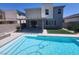 Inviting pool with tanning ledge, concrete patio, and artificial turf in a modern backyard at 10021 Locking Biner Ave, Las Vegas, NV 89166