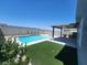 Inviting pool area with artificial grass and shaded patio is perfect for outdoor relaxation at 10021 Locking Biner Ave, Las Vegas, NV 89166