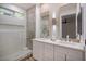 Bright bathroom featuring a glass shower, double vanity with modern fixtures, ample counter space, and stylish mirrors at 10025 Netherton Dr, Las Vegas, NV 89134