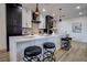 Stylish kitchen featuring contrasting black and white cabinets, a marble countertop island with seating, and modern pendant lights at 10025 Netherton Dr, Las Vegas, NV 89134