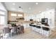 Spacious kitchen with an open floor plan, dining area, long island with seating, and modern, white cabinets at 10025 Netherton Dr, Las Vegas, NV 89134