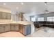 Open-concept living space with modern kitchen, staircase, and comfortable seating area with tiled and wood floors at 1073 Pleasure Ln # 2, Henderson, NV 89002
