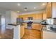 A bright kitchen featuring wooden cabinets, stainless steel appliances, and a breakfast bar with granite countertops at 1274 Doggett Ave, Las Vegas, NV 89123