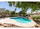 Inviting backyard oasis with a private pool, lush landscaping, and rock features at 1274 Doggett Ave, Las Vegas, NV 89123
