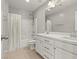 Bright bathroom with double vanity, and shower with white curtain and tile at 1556 Olivia Pkwy, Henderson, NV 89011