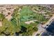 Aerial view of a vibrant golf course with meticulously manicured greens and swaying palm trees at 1556 Olivia Pkwy, Henderson, NV 89011